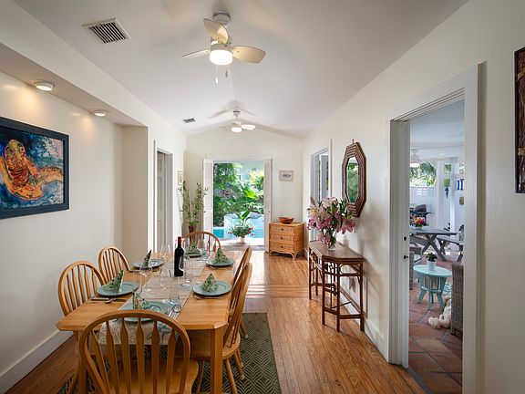 Dining table overlooks the pool and outside covered seating area.