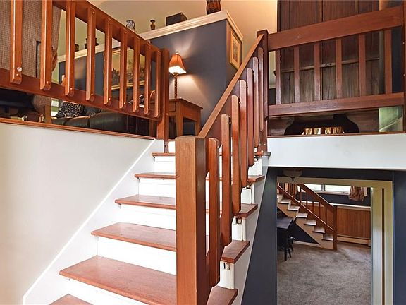 Cool, modern feel to the interior layout with view of front staircase, as well as back staircase to lower level family room with great natural light and a wood burning stove.