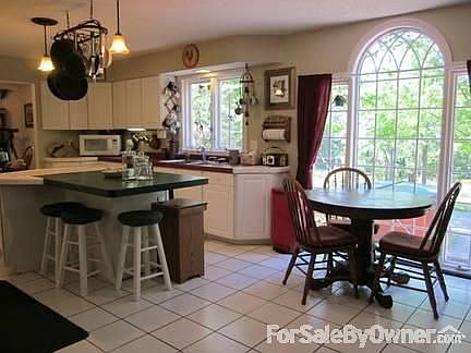Kitchen has island and lots of windows.