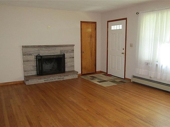 The spacious Greatroom features the gleaming, original hardwood flooring, a lighted Guest Closet, large, newer picture window for lots of natural lighting, and a neutral decor.