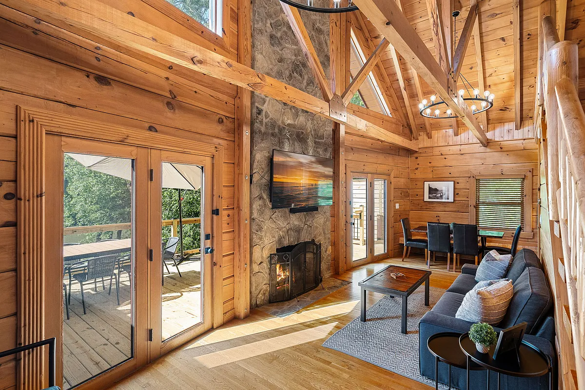 2 story family room with lake views. Glass doors on either side of the stone fireplace lead to outdoor deck. - Johnson Davis Rd