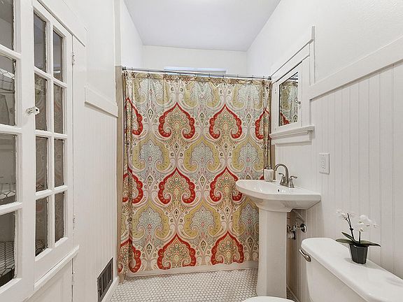 Beautiful bathroom with large Kohler sink and linen closet. Lovely wainscoting on walls