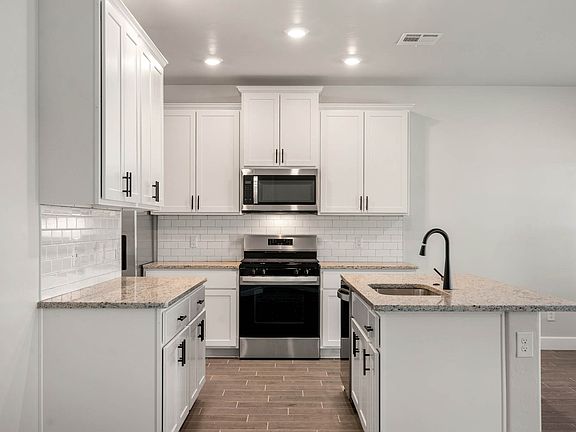 The upgraded kitchen has a gorgeous white cabinetry and matte black finishes.