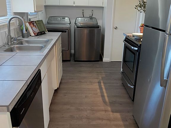Efficient galley kitchen with stainless steel appliances and Kenmore Elite washer and dryer