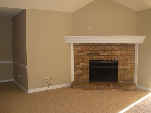 The Living Room has a wood-burning fireplace and large mantel. Please note this is the color of the carpet thru-out. Some photos reflect pink tint but that is only a representation of my photo skills, not the true color.