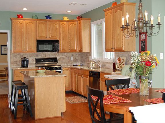 Upgraded Kitchen with Granite Countertops, Stone Backsplash, & Hardwood Floors