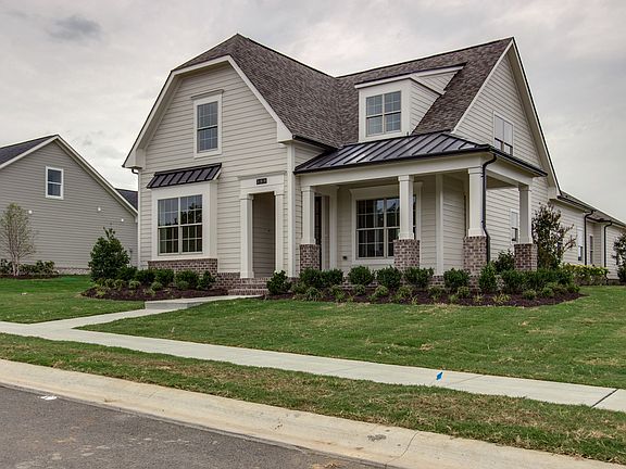 Awesome wrapped porch. Home faces treed common area.