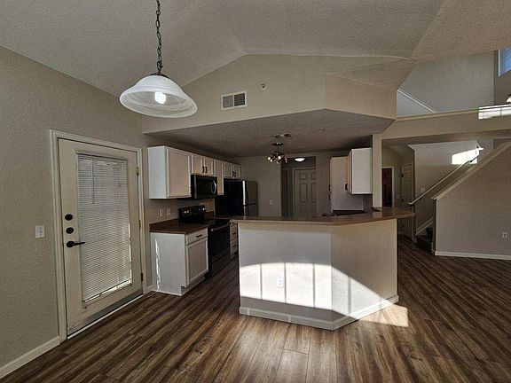 View into the sun soaked kitchen from separate dining area. Pictured at left is main entrance to 2nd balcony.