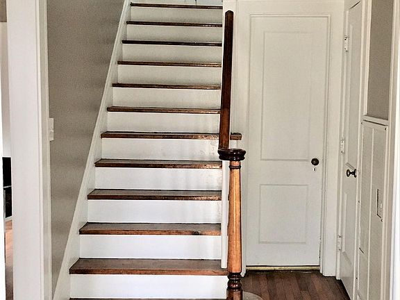 Classic center hall entry with living room to the left and dining room to the right. Door next to stairs leads to back hall access to kitchen, 1/2 bath, back door, and basement