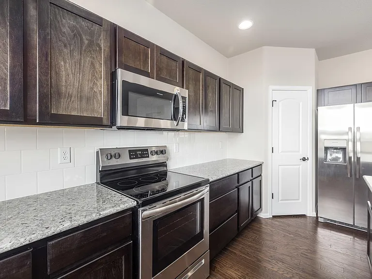 Beautiful Open Kitchen with Expresso Cabinets, Granite Countertops, Stainless Steel Appliances and LVP Flooring