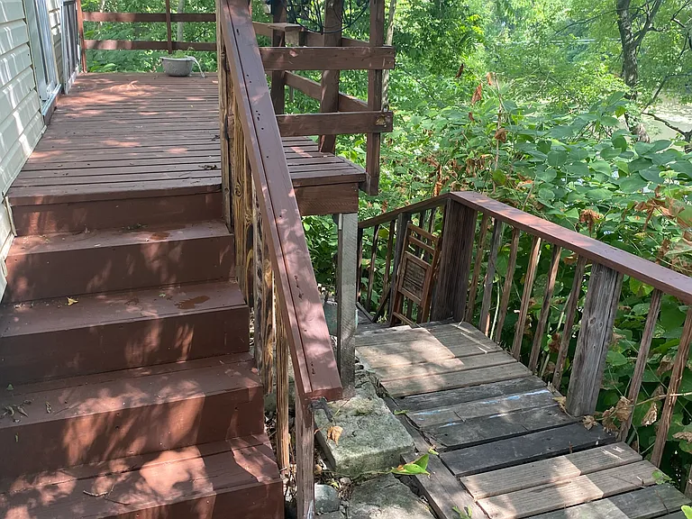 Upper deck off kitchen leading to lower deck near river