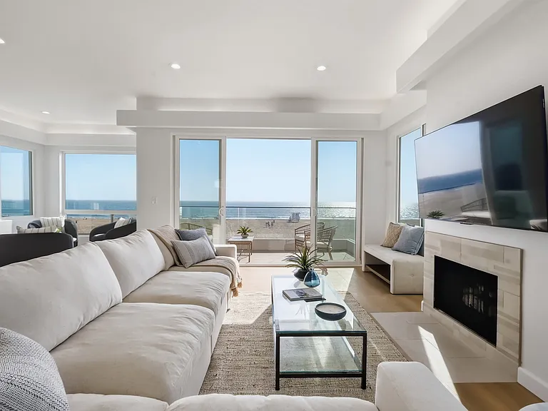 The main living room features breathtaking panoramic views from every corner, covered balcony, bar, and powder room.