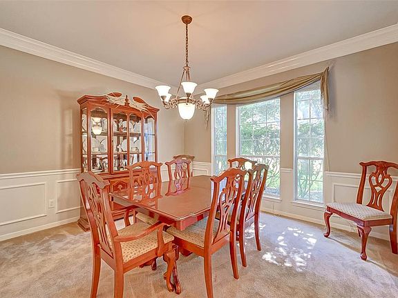 Formal dining room features luxurious wainscoting and a triple window overlooking the front yard.
