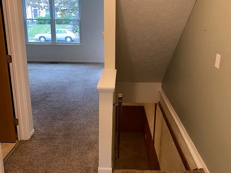 Second story hall. View into bedroom #2 and steps to first floor.