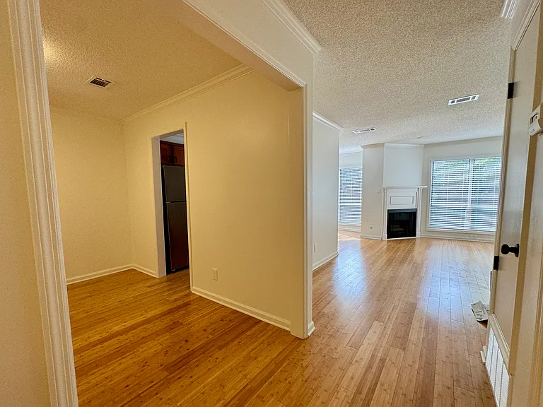office/bonus room at left with doorway into kitchen, hall leading to living room at right