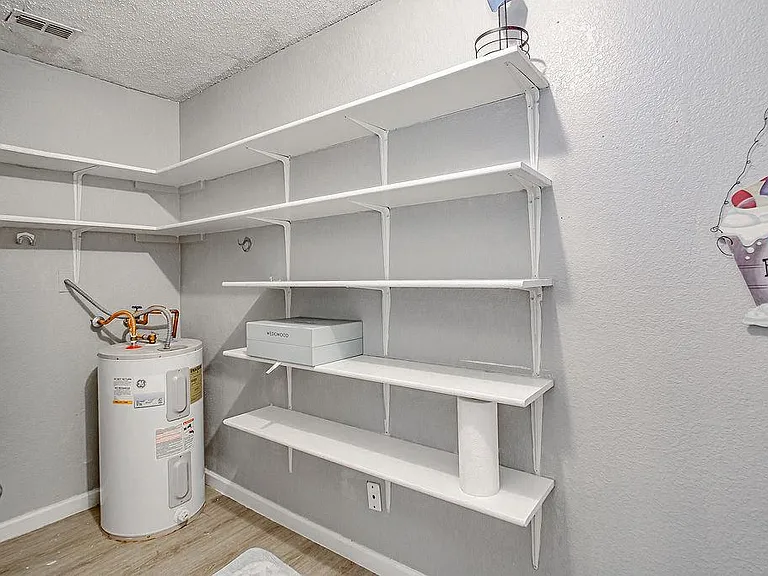 Dedicated utility/storage room with extensive built-in wall shelving for organized supplies and household essentials.