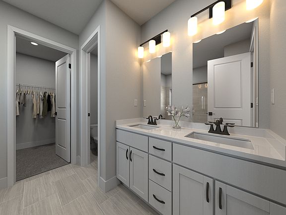 The primary bathroom offers dual vanity sinks and a walk-in shower.