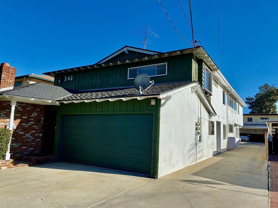 Exterior home view with off-street parking for 4 vehicles (2 garage spaces, 2 driveway spaces).