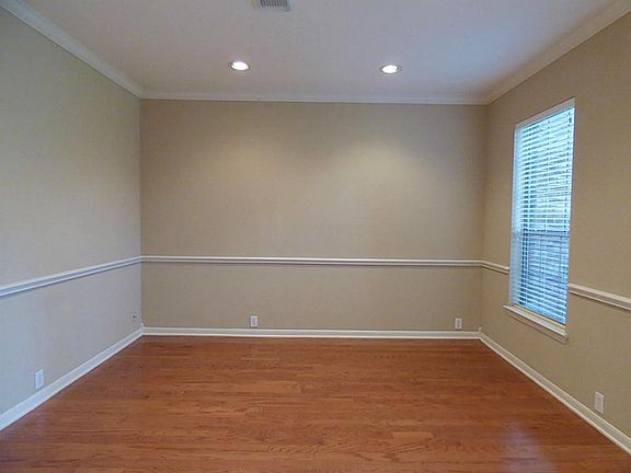 The formal dining room has hardwood floors, crown molding, chair railing and recessed lighting.