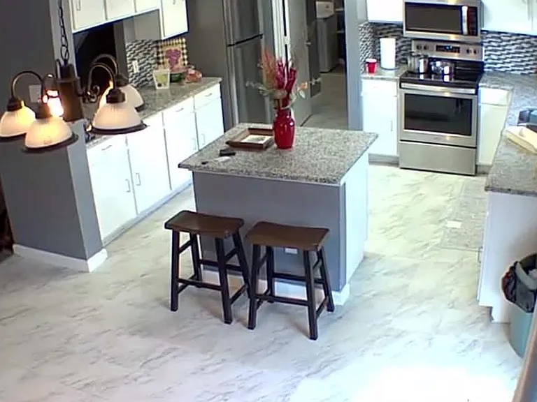 Kitchen with center island seating, ample cabinetry, granite-style counters, and stainless-steel appliances.