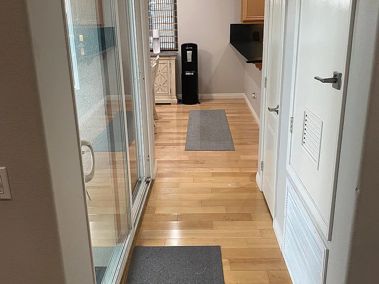 2nd floor hallway with door for storage on the right and patio to the left