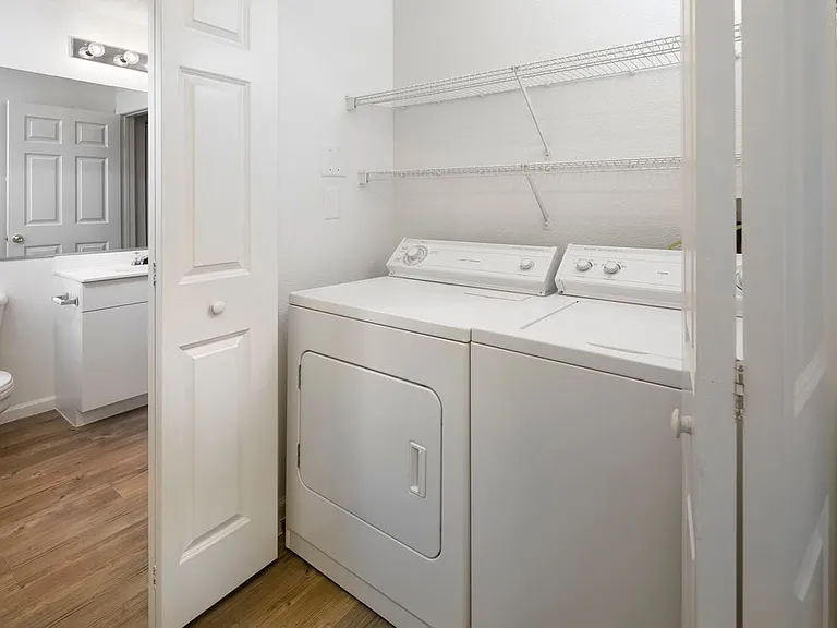 Wilmington Classic Package in-unit laundry and bath with white or beige laminate countertops, white cabinetry, and hard surface plank flooring