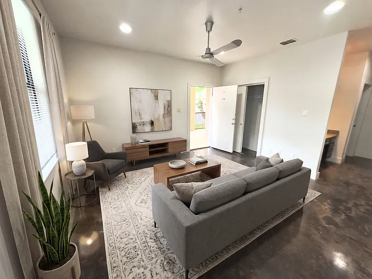 SPACIOUS LIVING ROOM WITH STAINED CONCRETE FLOORS THROUGH OUT FOR EASY CLEANING
