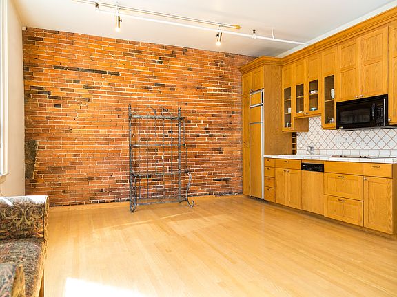 Exposed brick wall and kitchen area