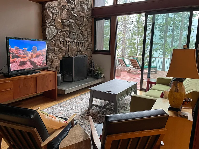 living room with big screen TV, 2 chairs, sofa for 3 and a wood-burning fireplace with gas starter. Great view of the lake.