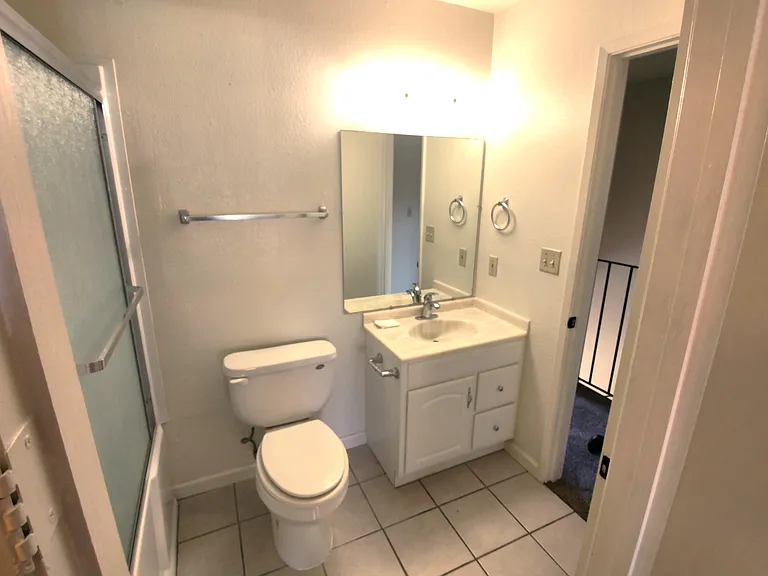 Bathroom, taken from the door connecting to the primary bedroom. The open door is to the hall, 2nd bedroom is to the left.