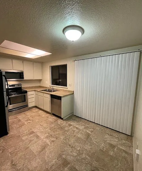 Kitchen with many cabinets and plenty of storage in pantry and refrigerator, stove & dishwasher.
