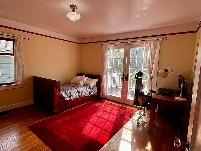 Spacious first floor bedroom with large closet. French doors to small deck with back garden views. Oak floors and picture rail moulding.