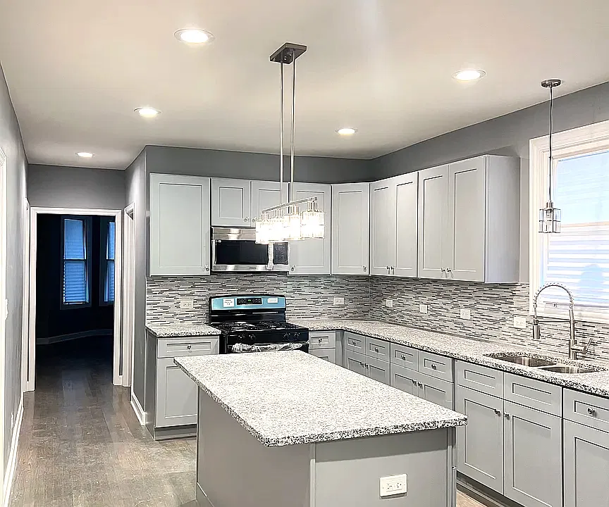 Brand new kitchen with light grey shaker cabinets and granite countertops