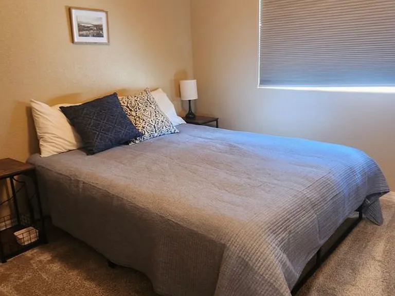 Queen bedroom with blackout shades for restful sleep.