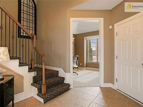 Beautiful two story entry boasts iron spindles on stairway and designer runner.