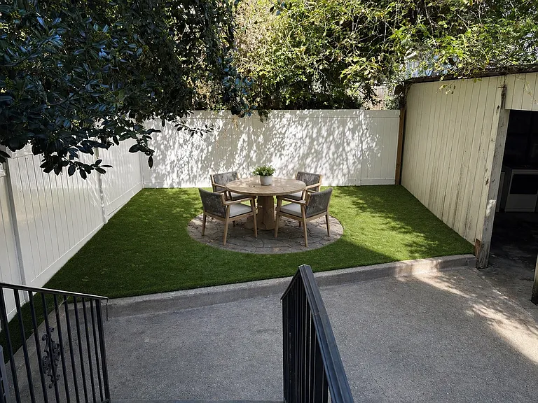Backyard with stone paver for the table and luxury artificial grass for year-round beauty and functionality. New table and chairs (similar to what's pictured here) included.