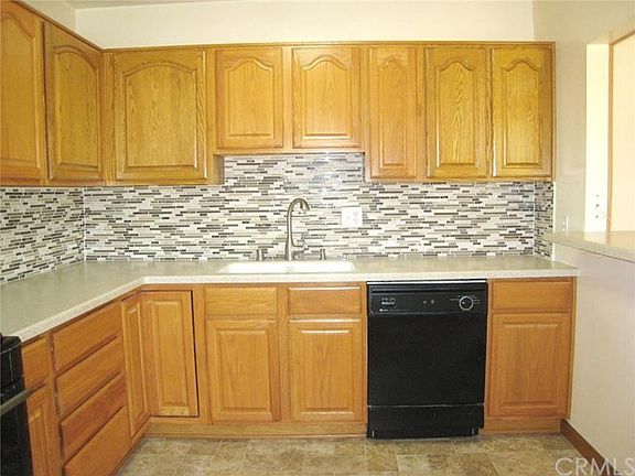 Beautifully recently remodeled kitchen with oak cabinets, built-in dishwasher, gas range and microwave. Vinyl floor really looks like tile!