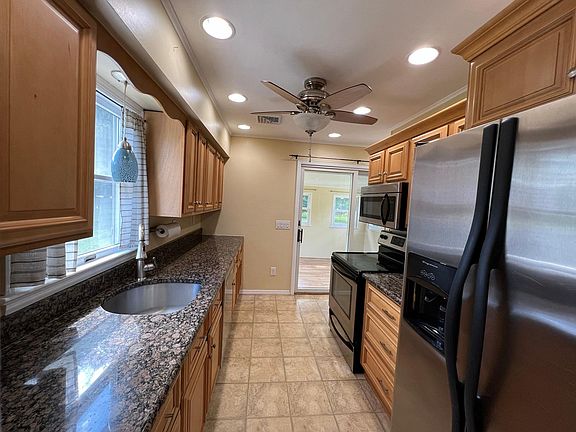 Galley kitchen with stainless steel appliances and granite countertops