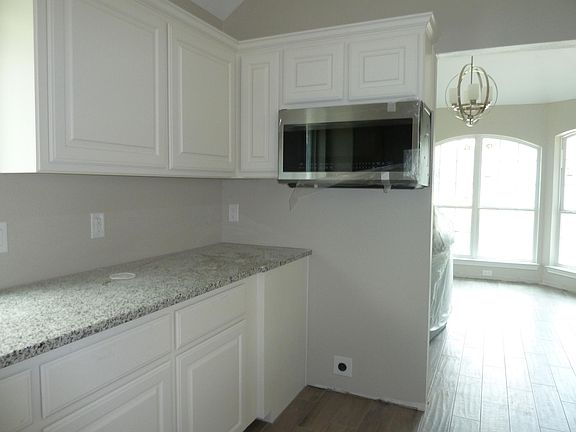 Kitchen with Samsung oversized microwave, electric smooth glass top range with convection oven to be installed.
