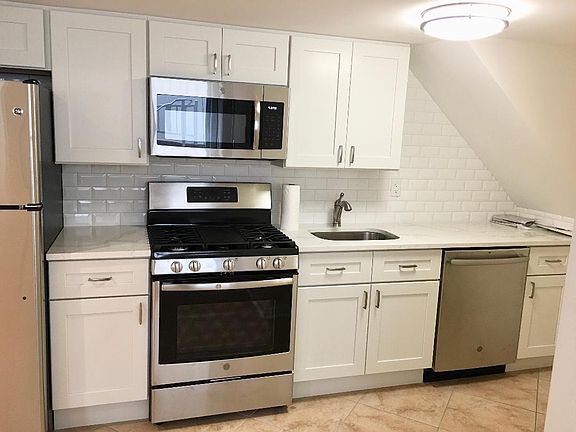 kitchen after renovations - new cabinets - new back splash - new stainless steel appliances - stove - refrigerator, microwave and dishwasher