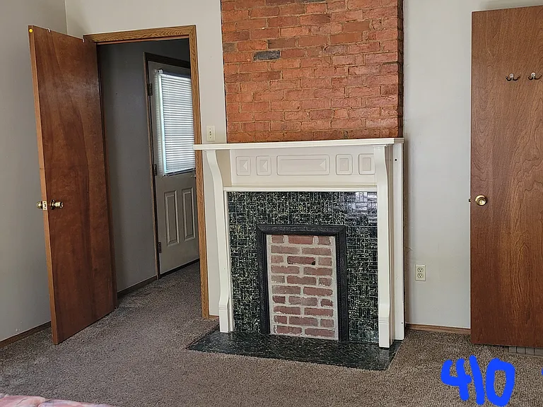 Bedroom showing the decorative fireplace, closet and door into the living room.