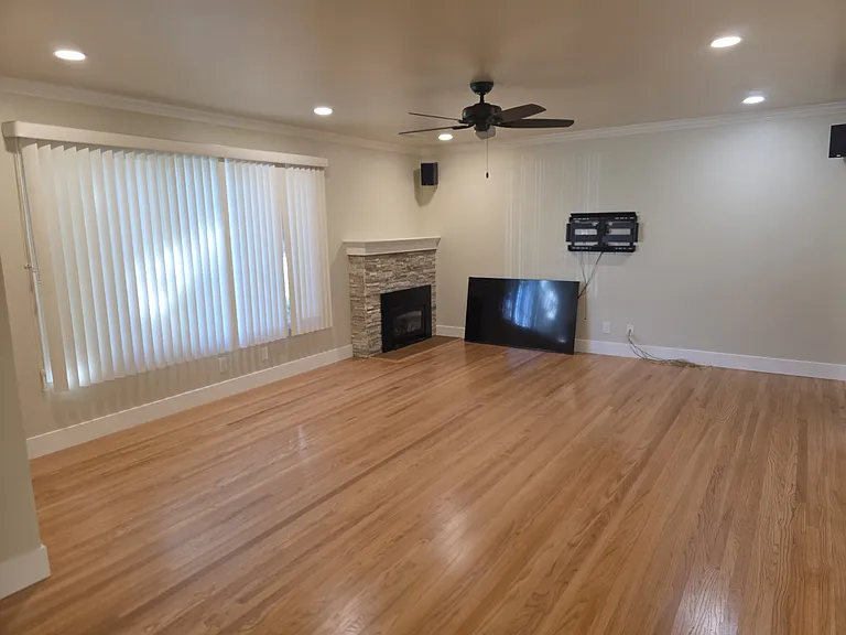 Living room with gas fireplace, hardwood floors.