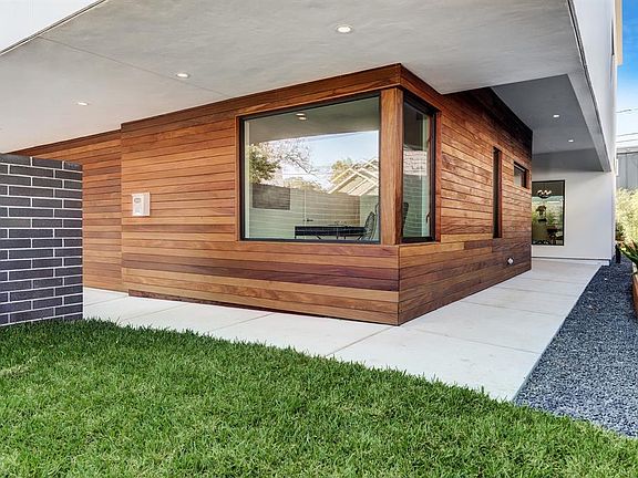 The Cumaru wood, brick and Black Star crushed granite accented walk way leads you into the home.