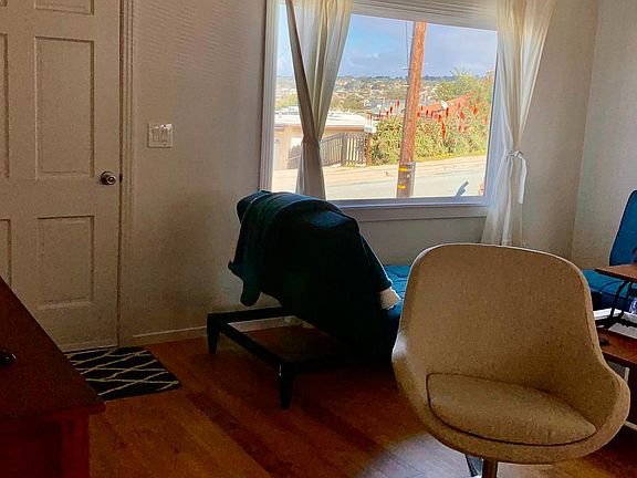 Living room from the hallway. You can see the view of the town of Seaside out the front window. The coffee table lifts up to be a desk.