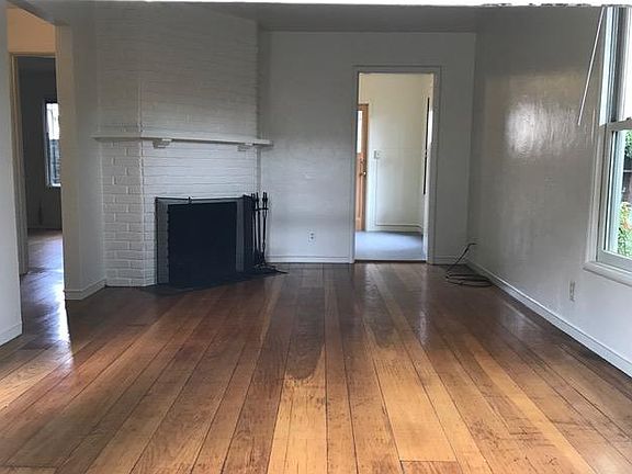 Living room with fireplace with window to private, fenced yard.