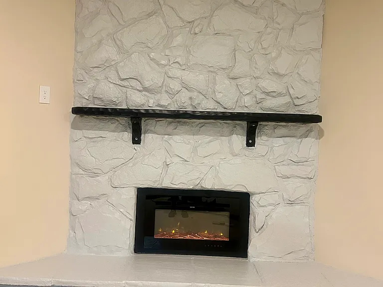The new living room floor to ceiling fieldstone fireplace is a wonderful focal point and is already set up for you to put your tv on the mantle with an electrical outlet to the left.