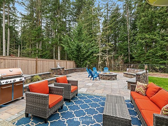 Resort -like backyard backs to a lush greenbelt for beautiful privacy. Large paver patio, Water feature, firepit, built-in bench!