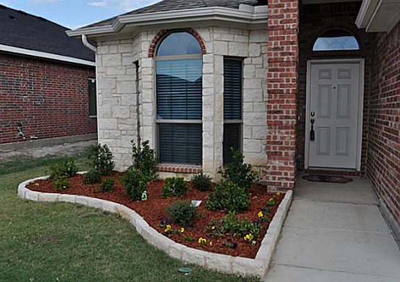 Covered front Porch with beautiful landscaped yard & spr