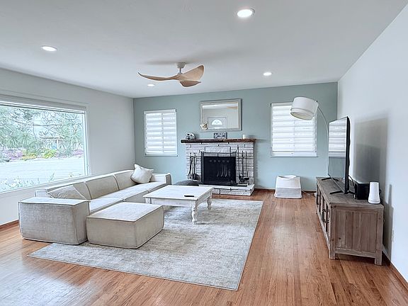 Bright and inviting living room with 65 inch TV and large West-facing window.