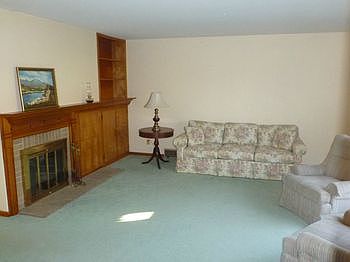 Living Room with Woodburning Fireplace and Large Picture Window